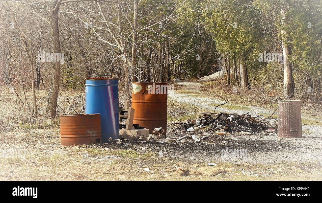Garbage and old rusty cans dumped beside walking trail Stock Photo Alamy