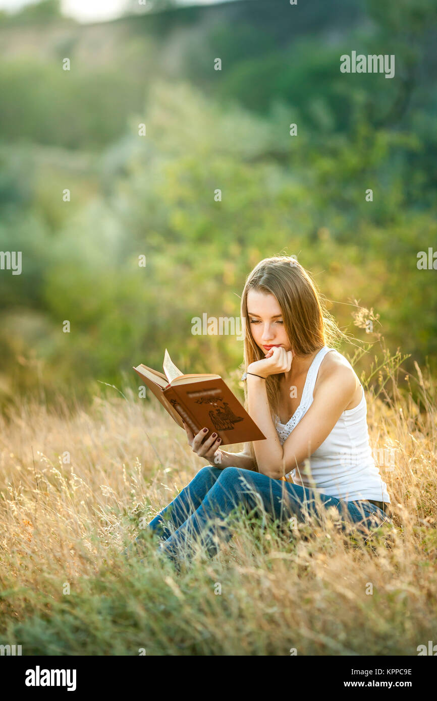 Beautiful girl reading a book on the Nature Stock Photo - Alamy