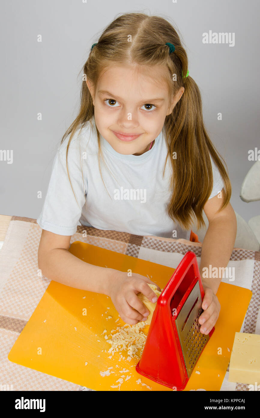 The little girl at the table t grated cheese Stock Photo Alamy