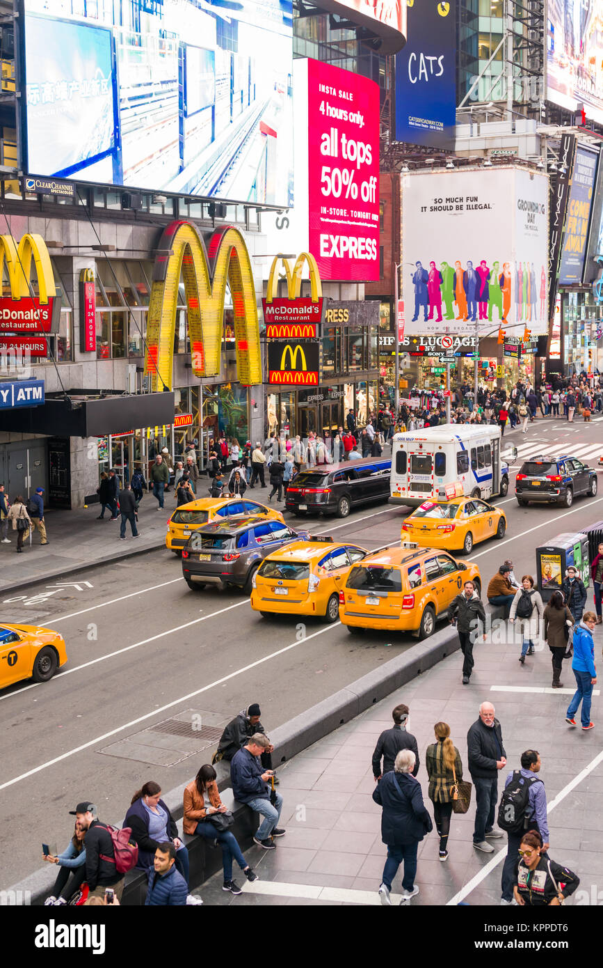 View of Times Square showing 7th Avenue buildings and traffic with people walking on pavement, New York, USA Stock Photo