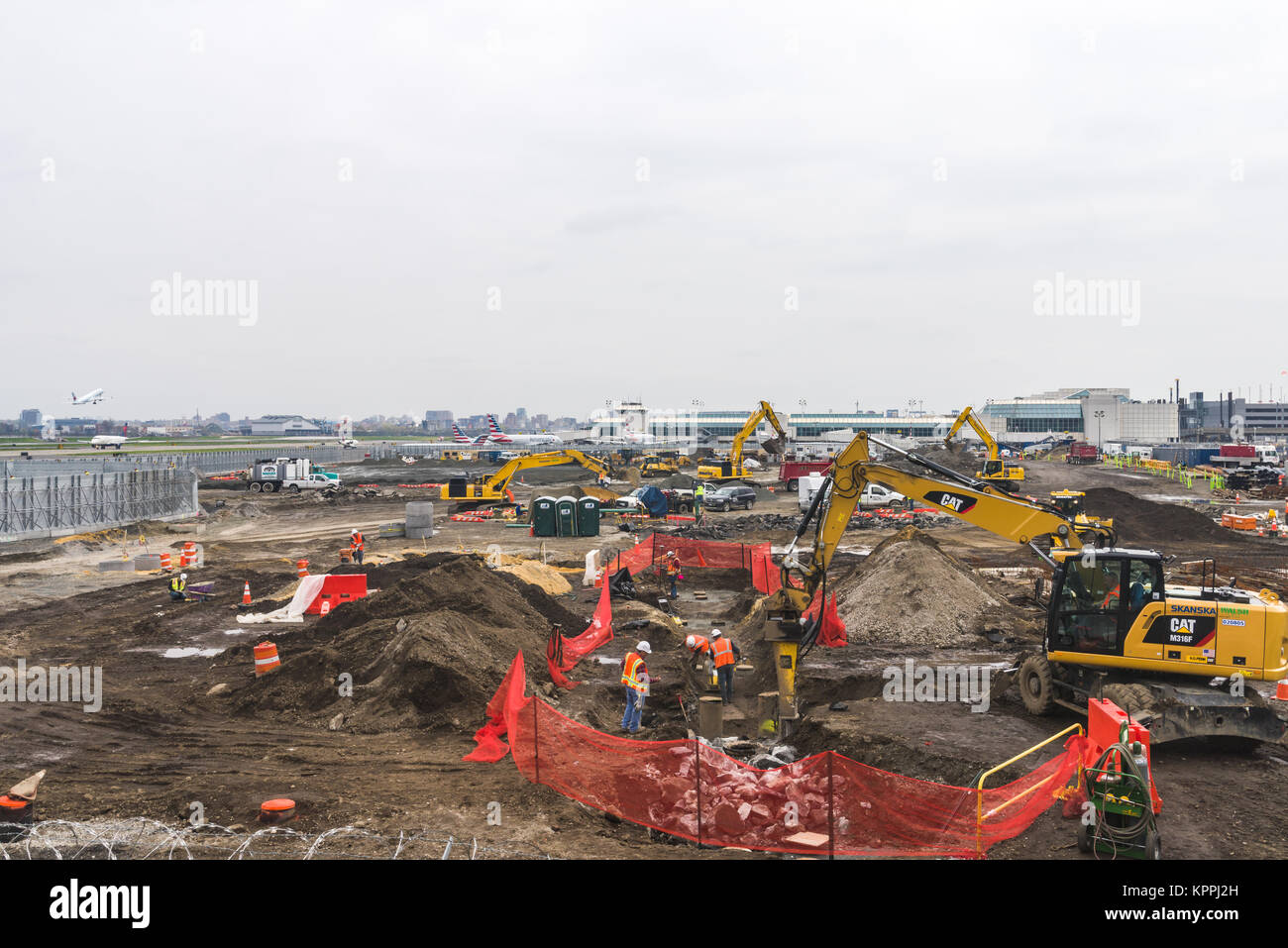 Construction equipment and workers building the new terminal at La