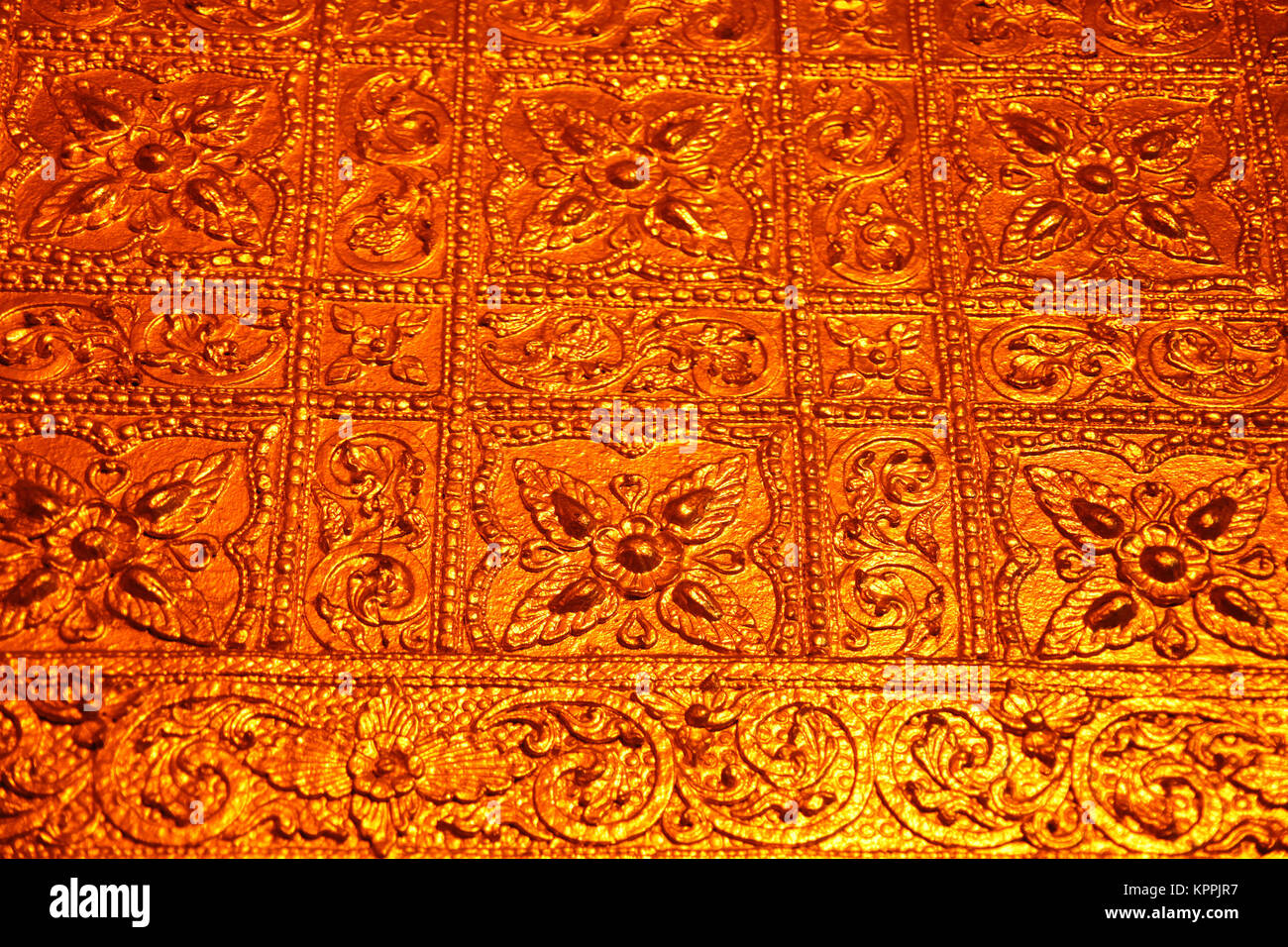 Close up of a golden wall designed with flowers inside the Buddhist Botataung pagoda, Yangon, Myanmar. Stock Photo