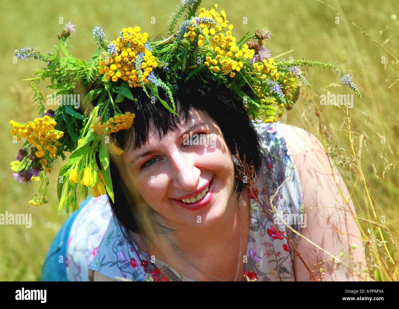 Happy smiling girl with a wreath of wildflowers on her head Stock Photo ...