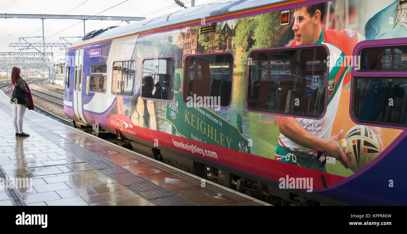 A female passenger waits to board a Keighley branded Northern Arriva Rail North train bound for Carlisle at Leeds Railway Station Stock Photo