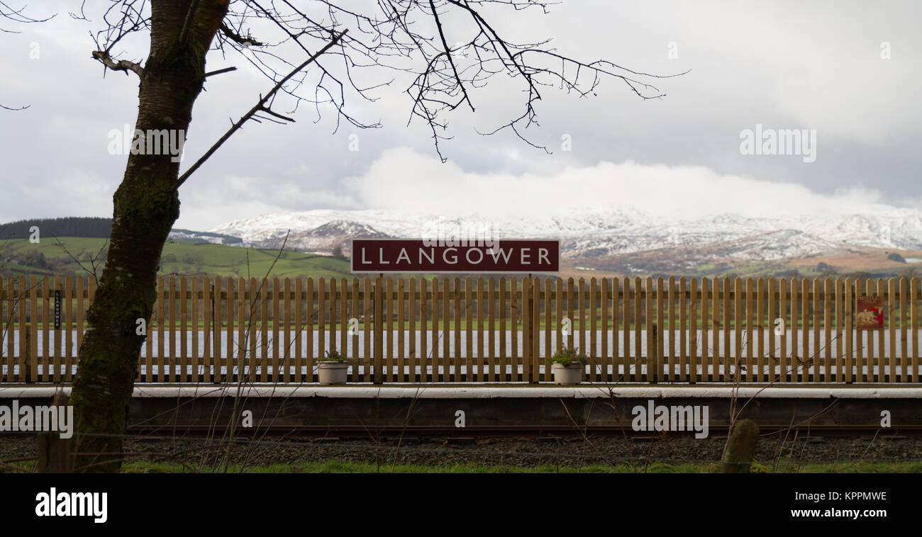 Llangower Railway Station, Bala Lake Railway with station name board, Lake and Mountains behind, Snow in Snowdonia Winter Scene Stock Photo