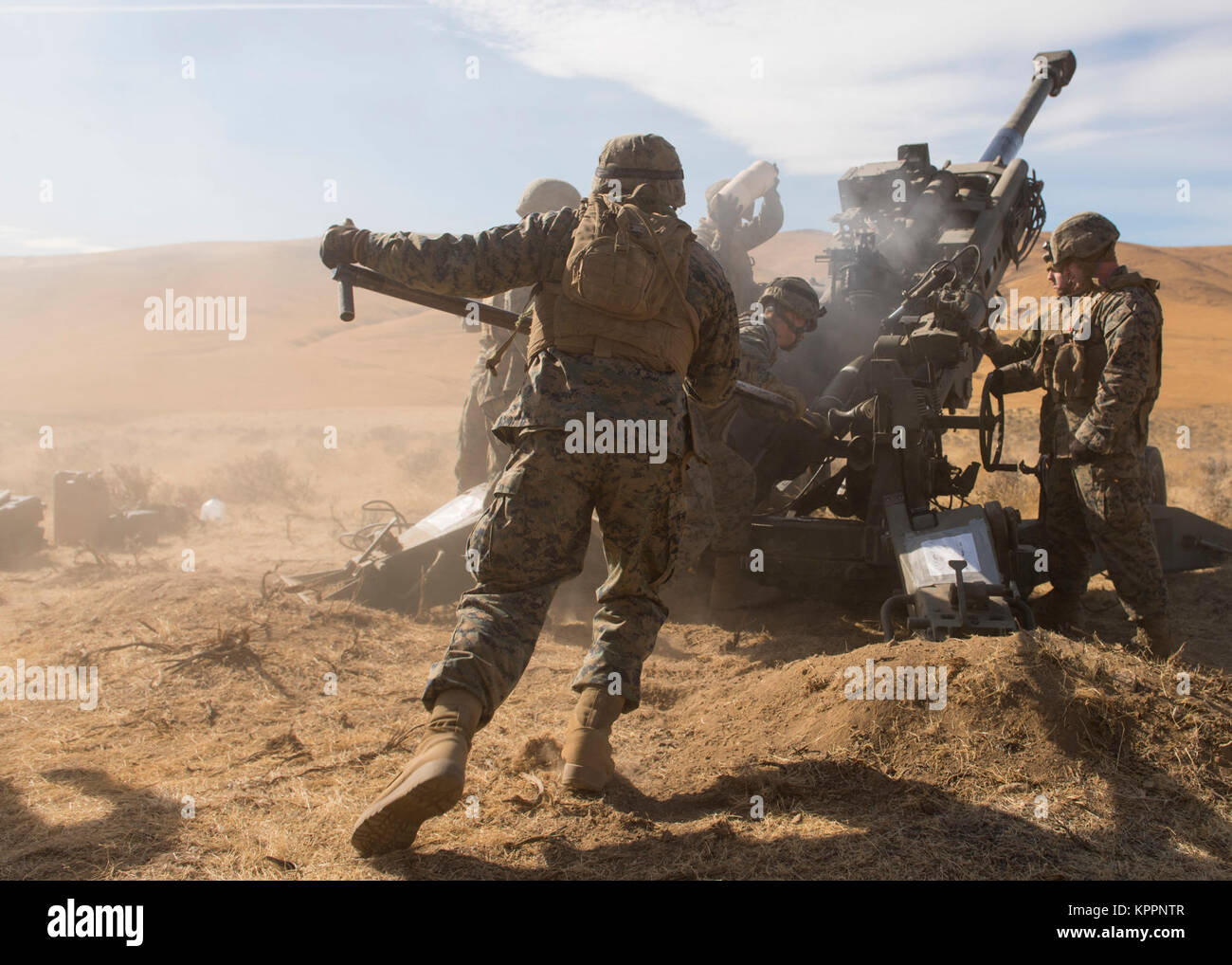 Marines of P Battery 5/14 use a ramming rod to push a 100-pound, high ...