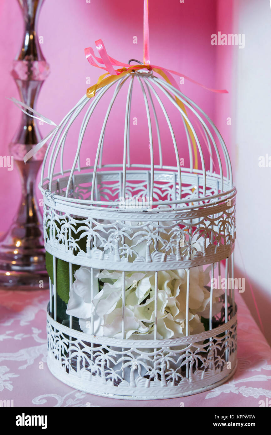 The cage with flowers stand in restaurant . white roses put on the top