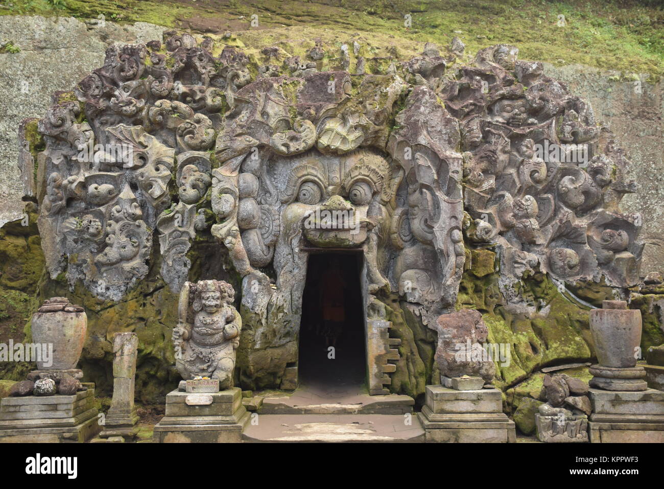 The entrance of Goa Gajah sanctuary (also called Elephant cave) with various menacing creatures and demons carved into the rock in Bali - Indonesia Stock Photo