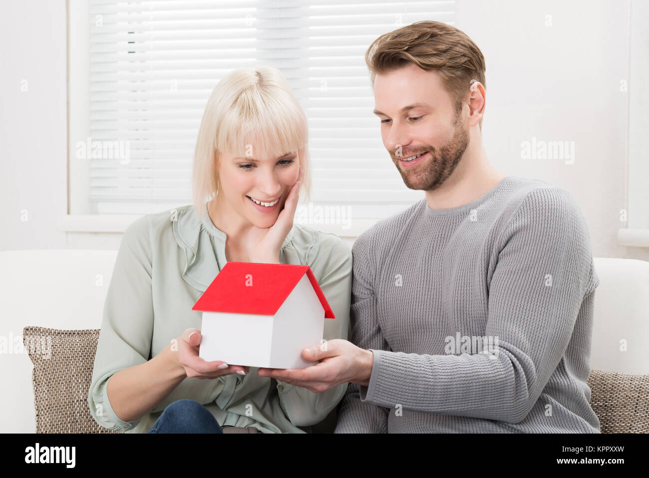 Couple Holding A House Model Stock Photo - Alamy