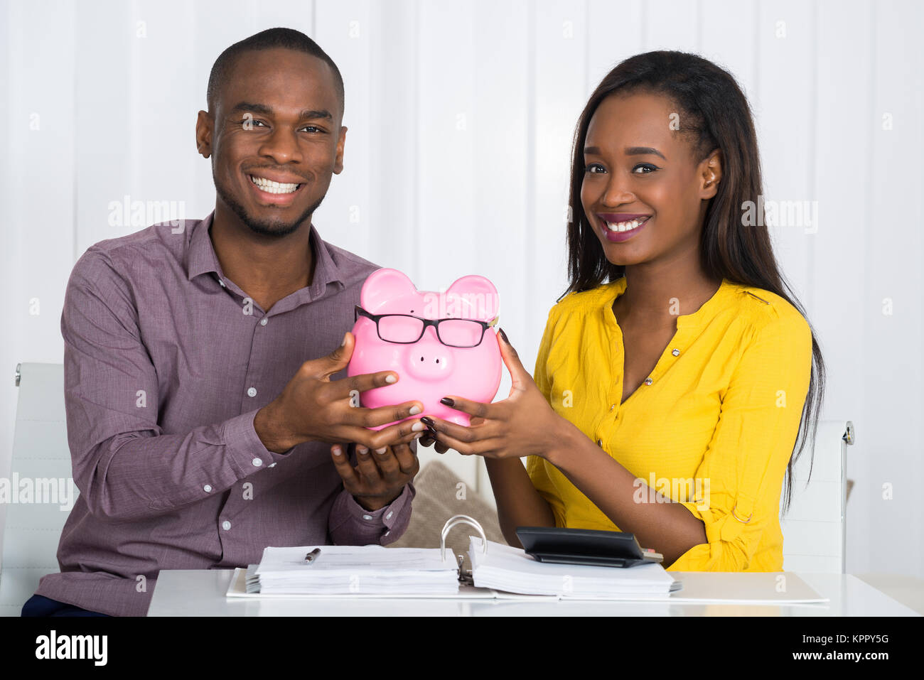 Happy Couple Holding Piggybank Stock Photo - Alamy