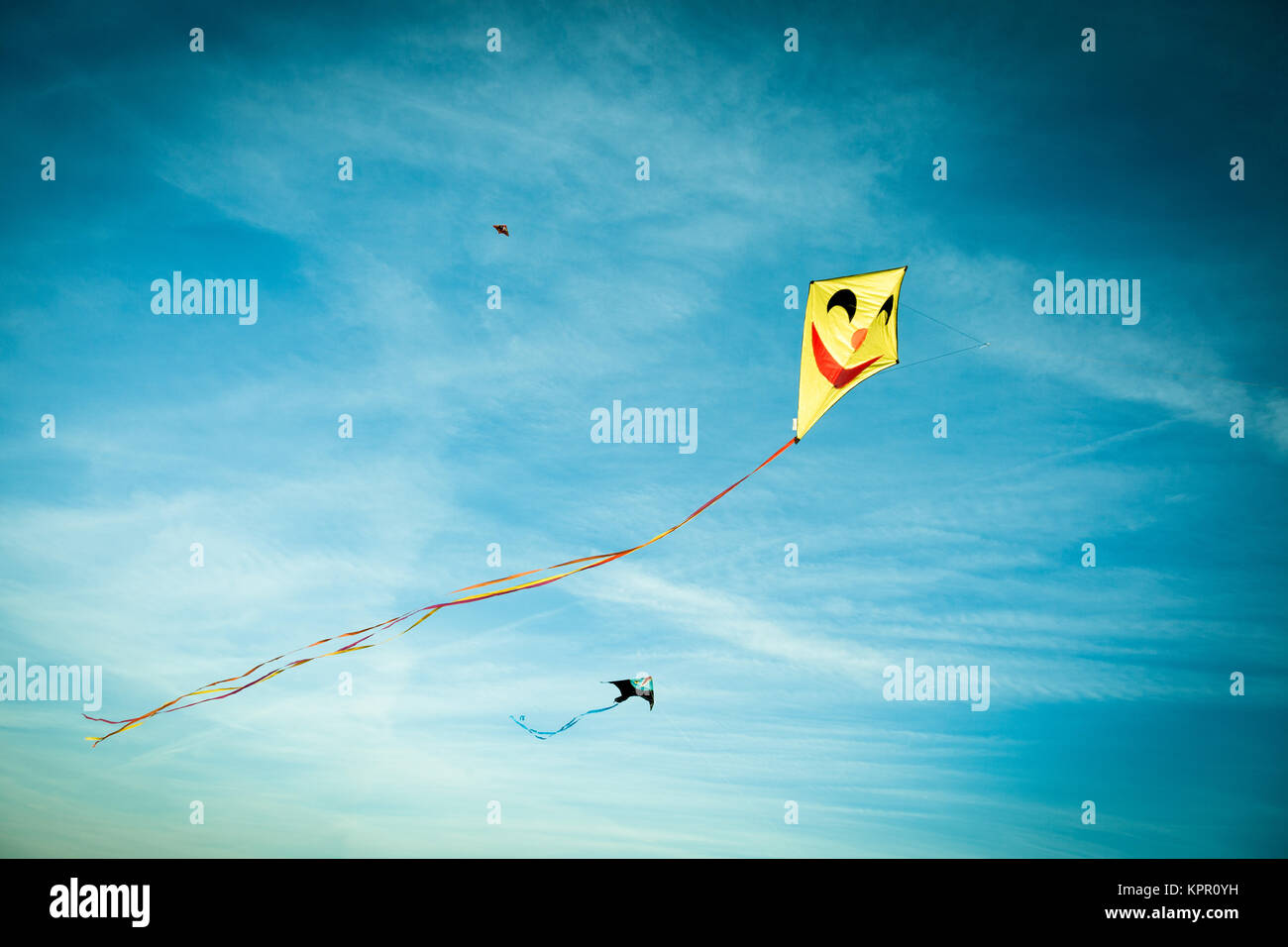 A colorful kite in the blue sunny sky Stock Photo