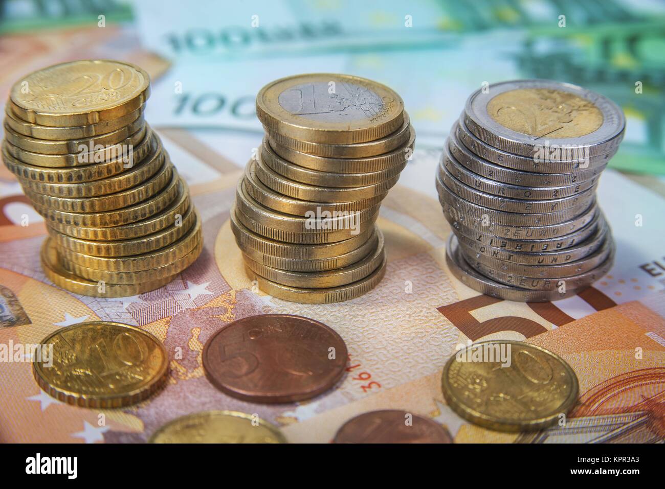 Stacked one and two Euro coins with paper banknotes Stock Photo - Alamy