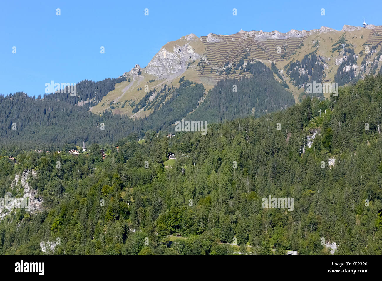 Rocky peaks and wooded slopes and smaller hills as seen from Lauterbrunnen Stock Photo
