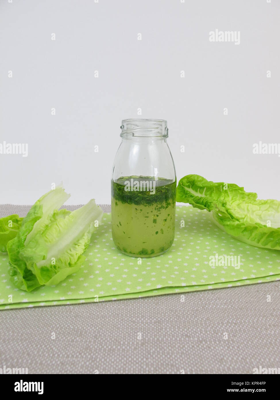 herb vinaigrette in the bottle and salad leaves Stock Photo
