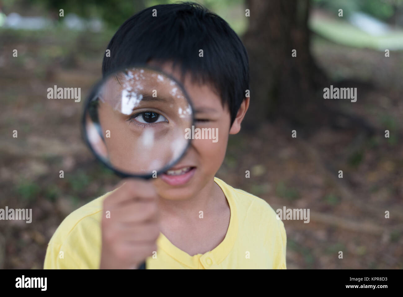young asian boy looking through magnifying glass. education concept Stock Photo