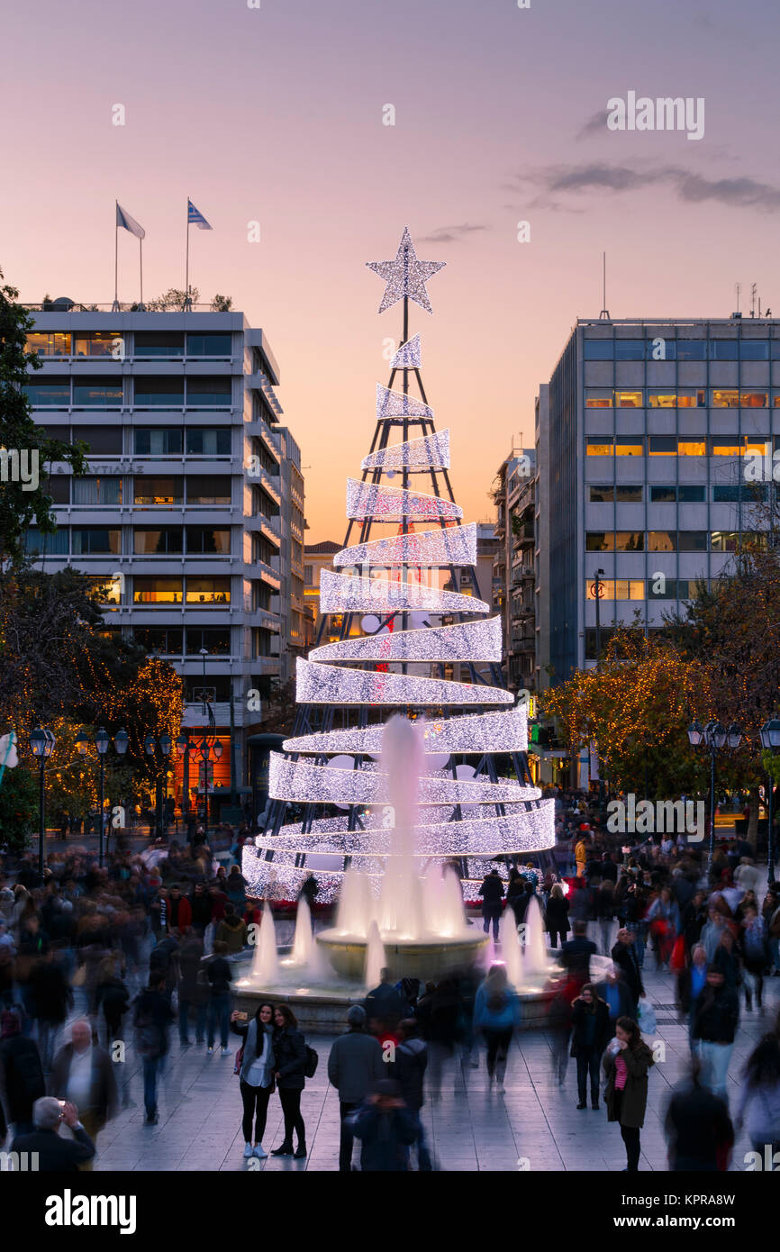 People in Syntagma square with a large Christmas tree it its center