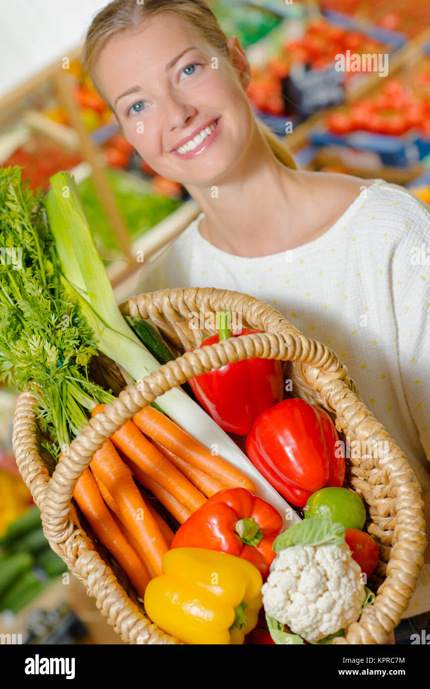 Woman holding up her shopping basket Stock Photo - Alamy