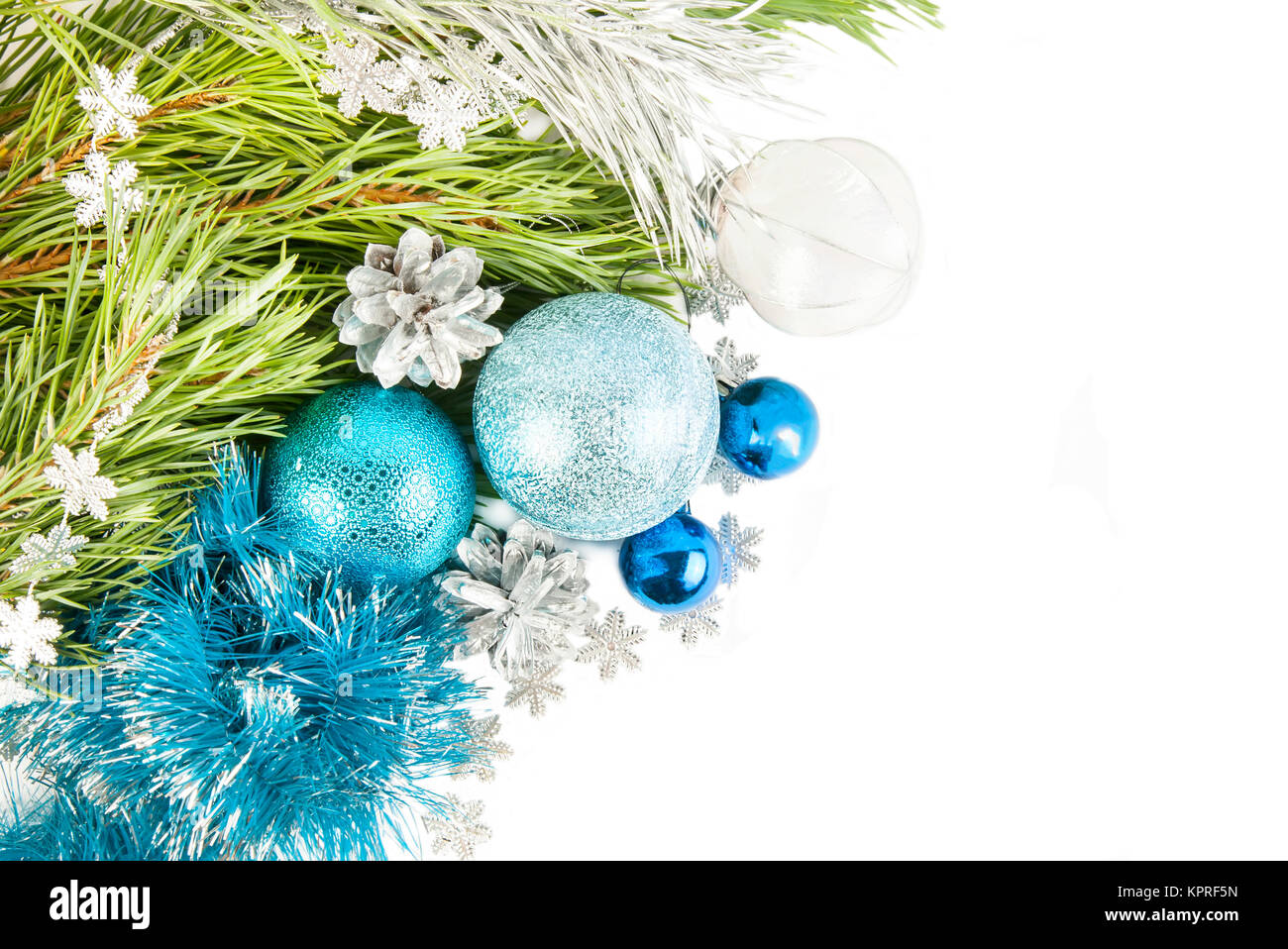 New Year composition with fir tree branch and cones with blue balls and tinsel isolated on white background Stock Photo
