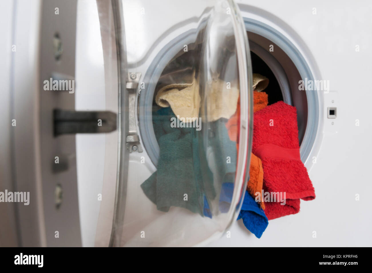 Hausarbeit, Waschservice, Waschmaschine mit bunter Waesche. Stock Photo