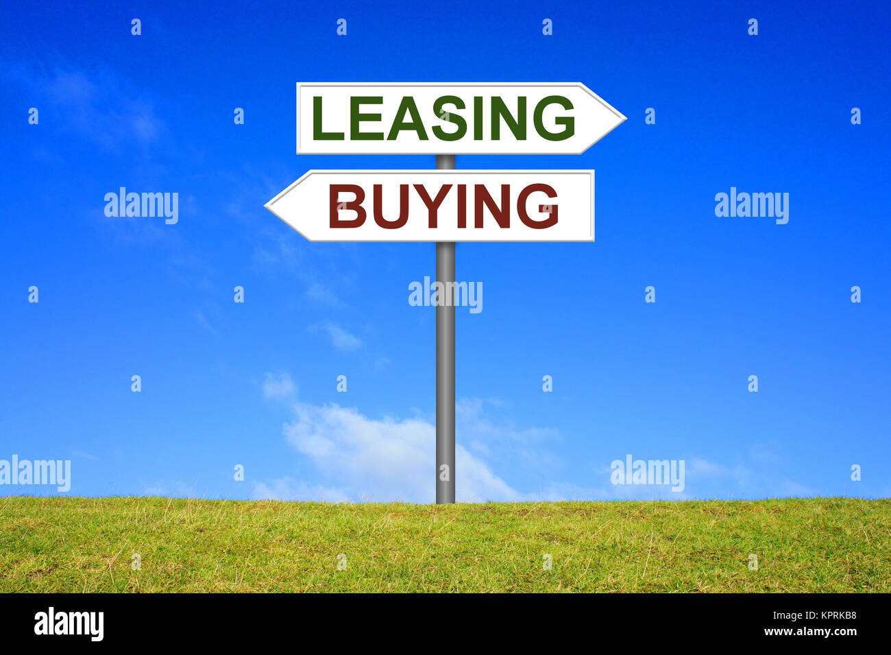 Schild Wegweiser auf einer Wiese vor blauem Himmel zeigt in Richtung Buying oder Leasing Stock Photo