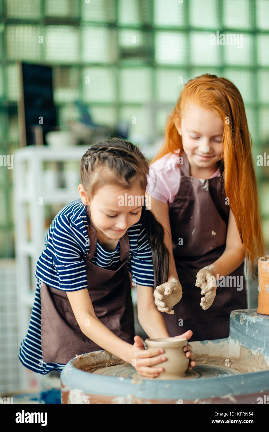 pottery girls sculpts from clay on pottery wheel Stock Photo