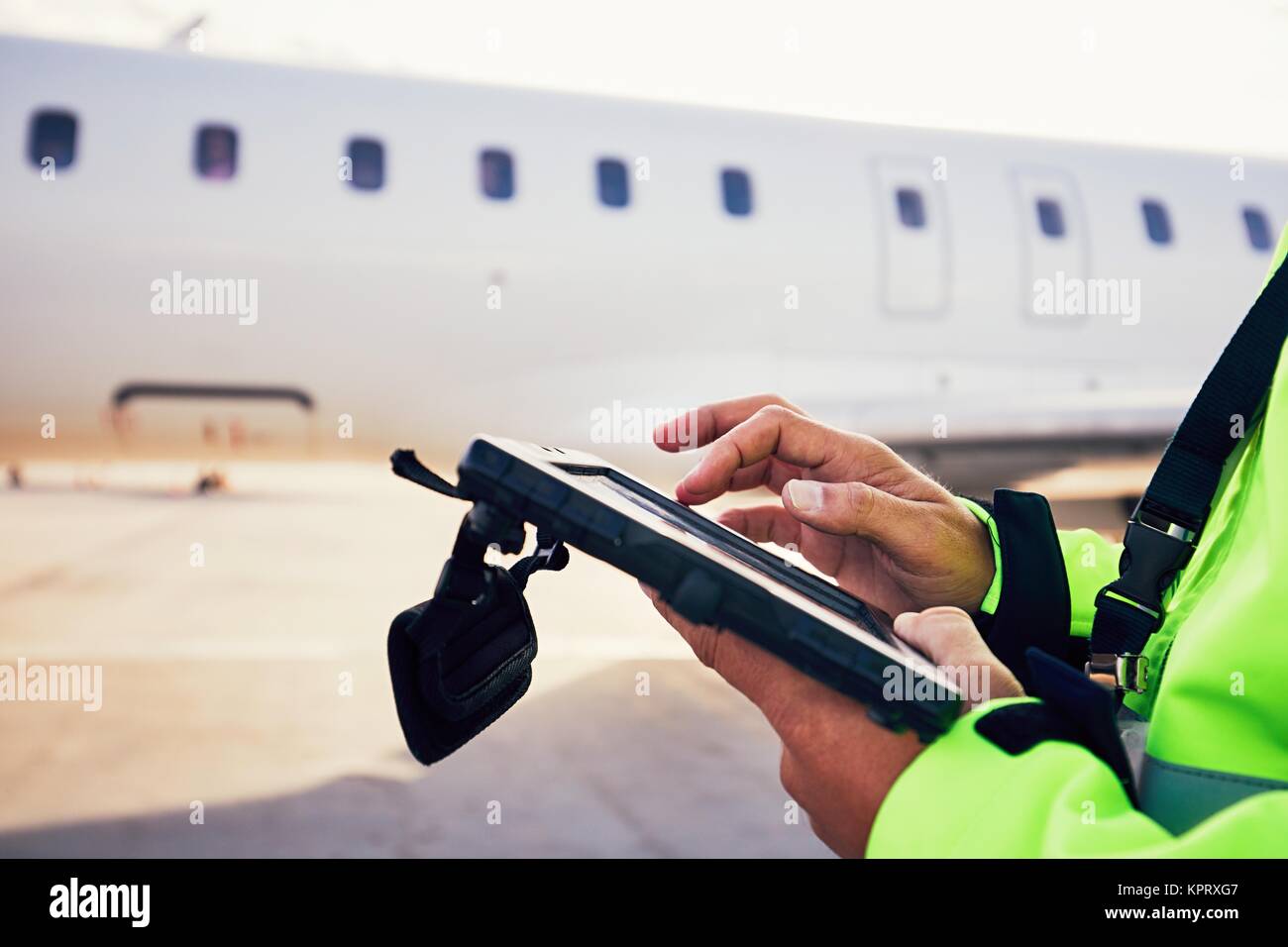 Modern technology at the airport. Member of the ground staff preparing the passenger airplane before flight. Stock Photo