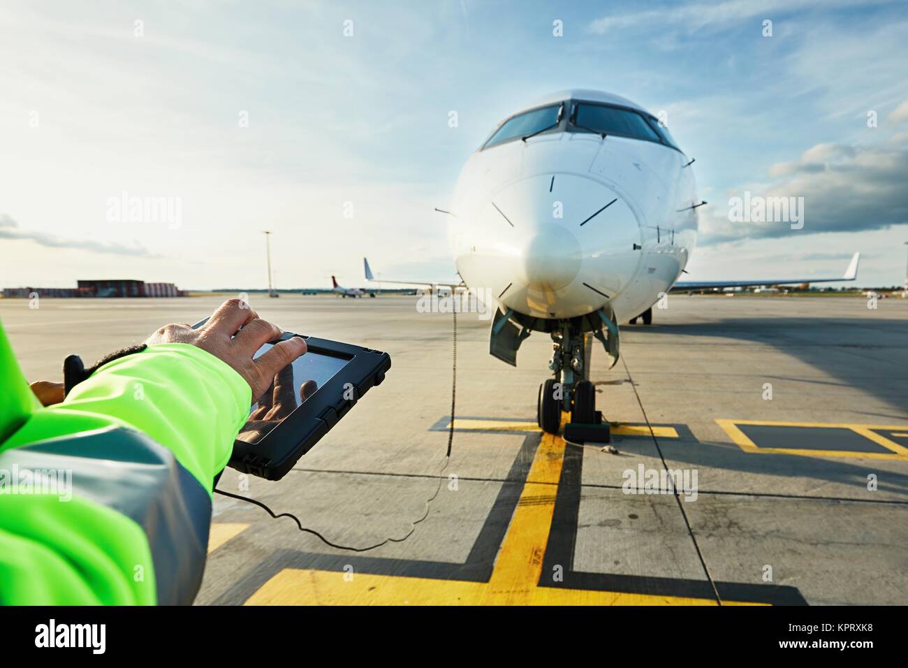 Modern technology at the airport. Member of the ground staff preparing the passenger airplane before flight. Stock Photo