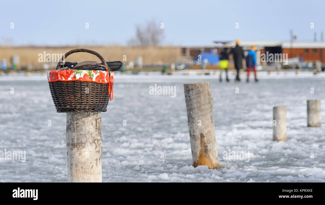 Picnic basket with shoes while ice skating at the lake Stock Photo