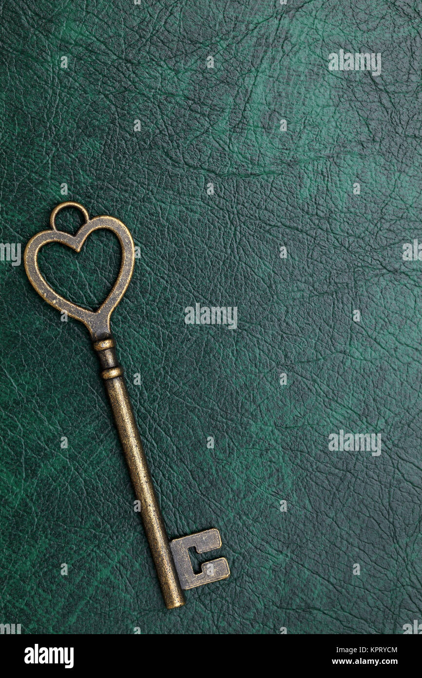 heart shaped vintage key on a leather background Stock Photo - Alamy
