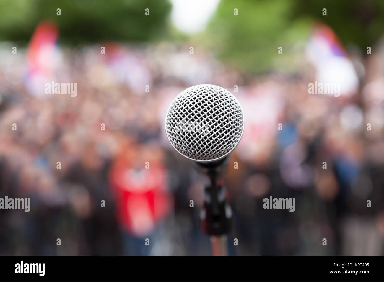 Microphone in focus against blurred audience. Political rally. Stock Photo