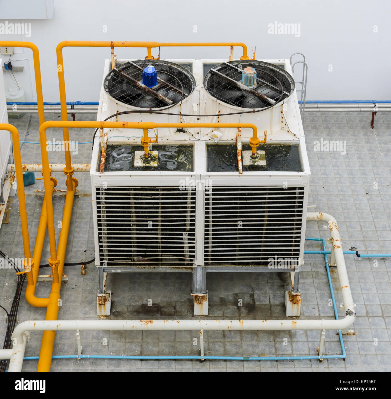 Industrial cooling towers or air cooled water chillers with piping system  on building rooftop Stock Photo - Alamy