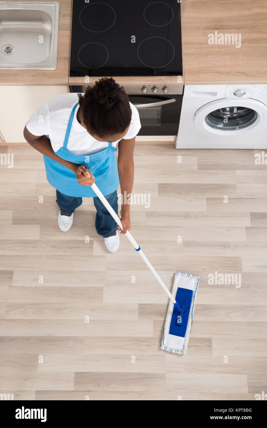 Female Janitor Cleaning Floor In Kitchen Stock Photo Alamy