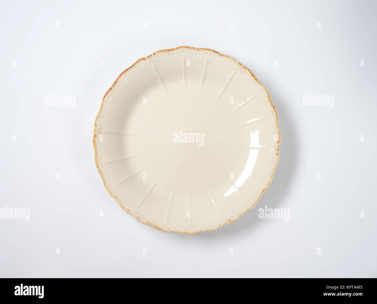 dinner plate with embossed lines and subtle scalloped edge Stock Photo