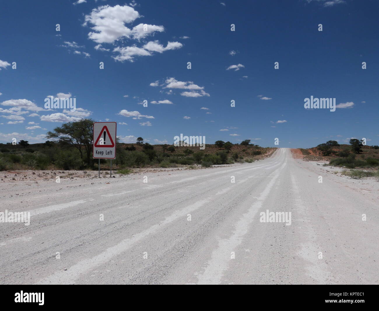 Gravel road in Namibia with sign 'Keep left' Stock Photo