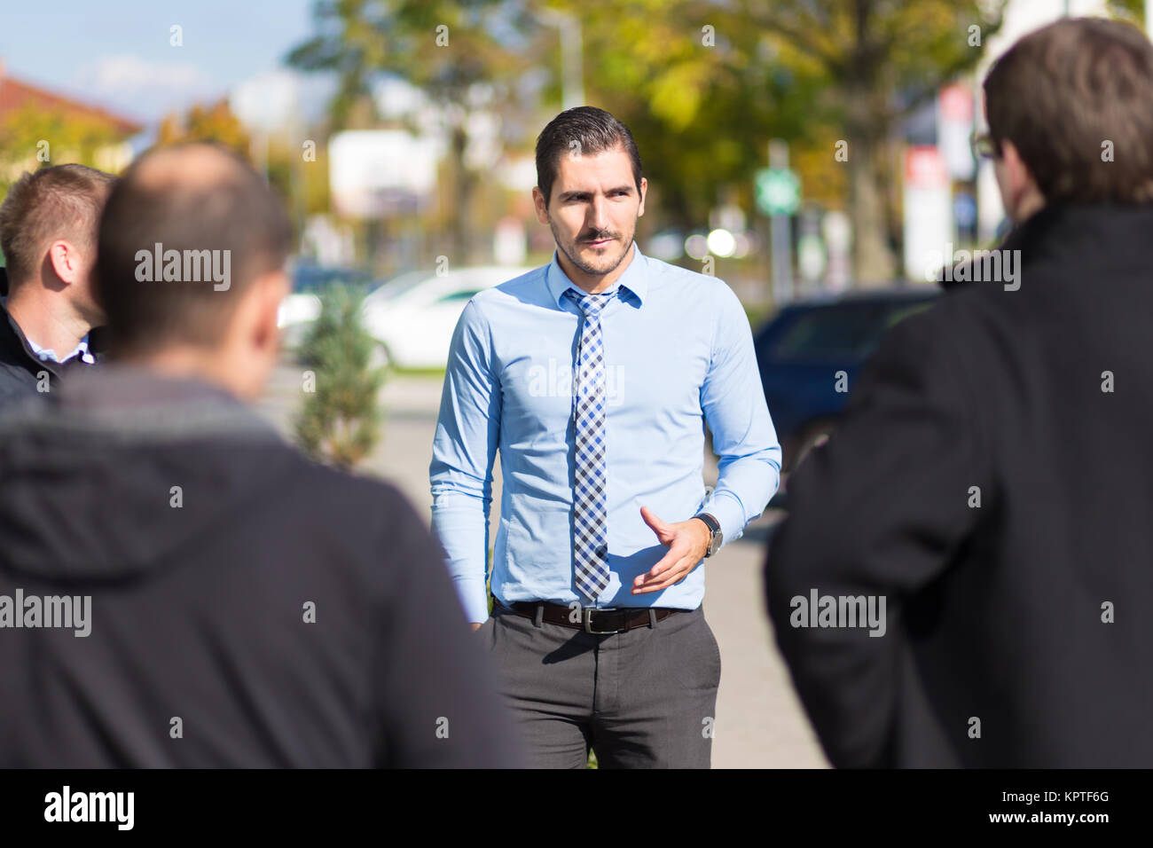 Businessman being approached and blackmailed by racketeers. Stock Photo