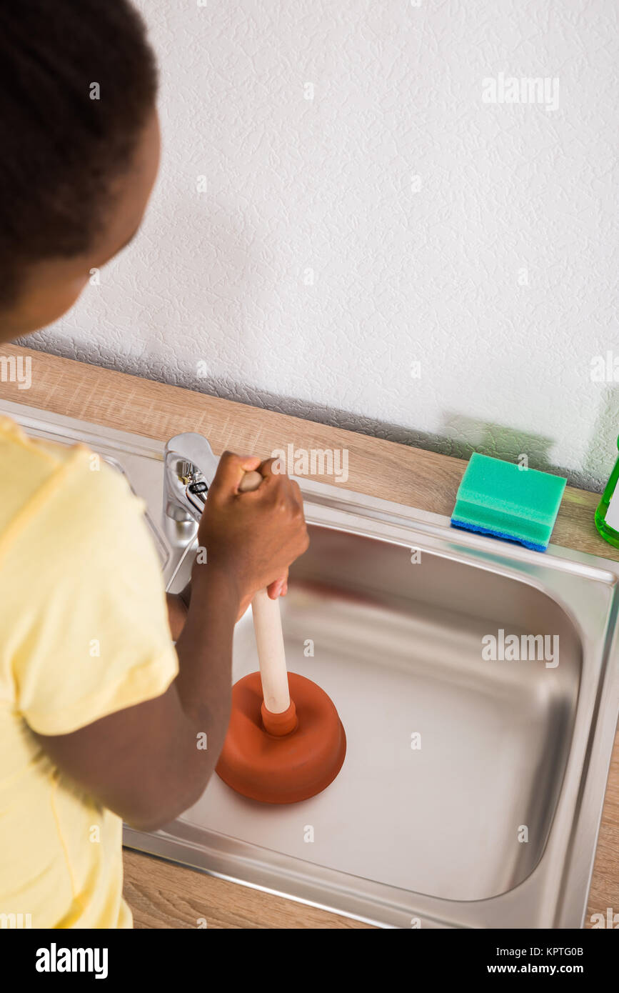 Woman Using Plunger In Sink Stock Photo Alamy