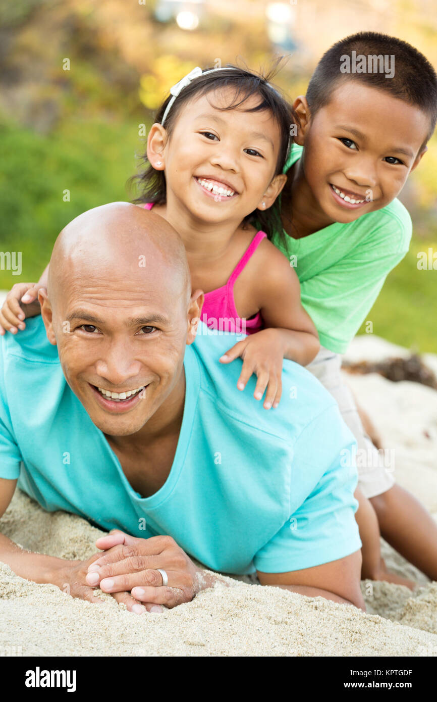 Father playing with his kids on the beach. Stock Photo
