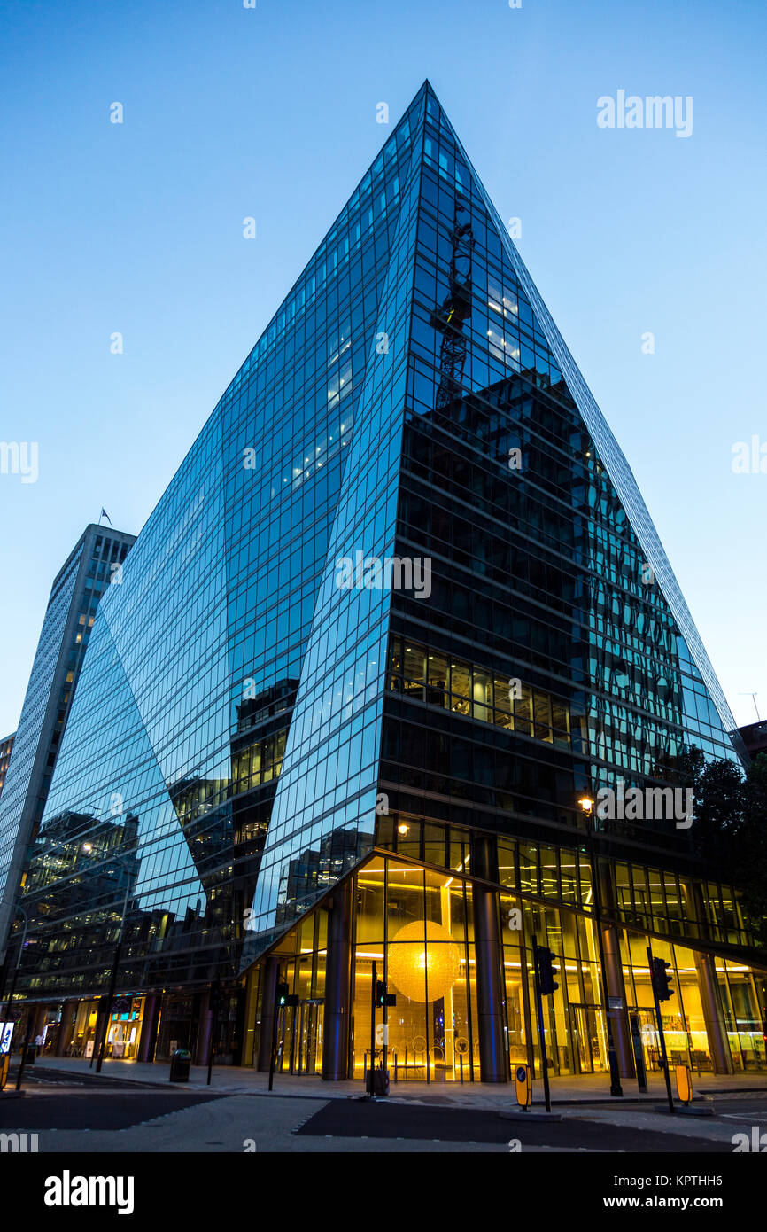 Modern, glass asymmetrical building at dusk (Selborne House, Victoria Street, London, UK) Stock Photo