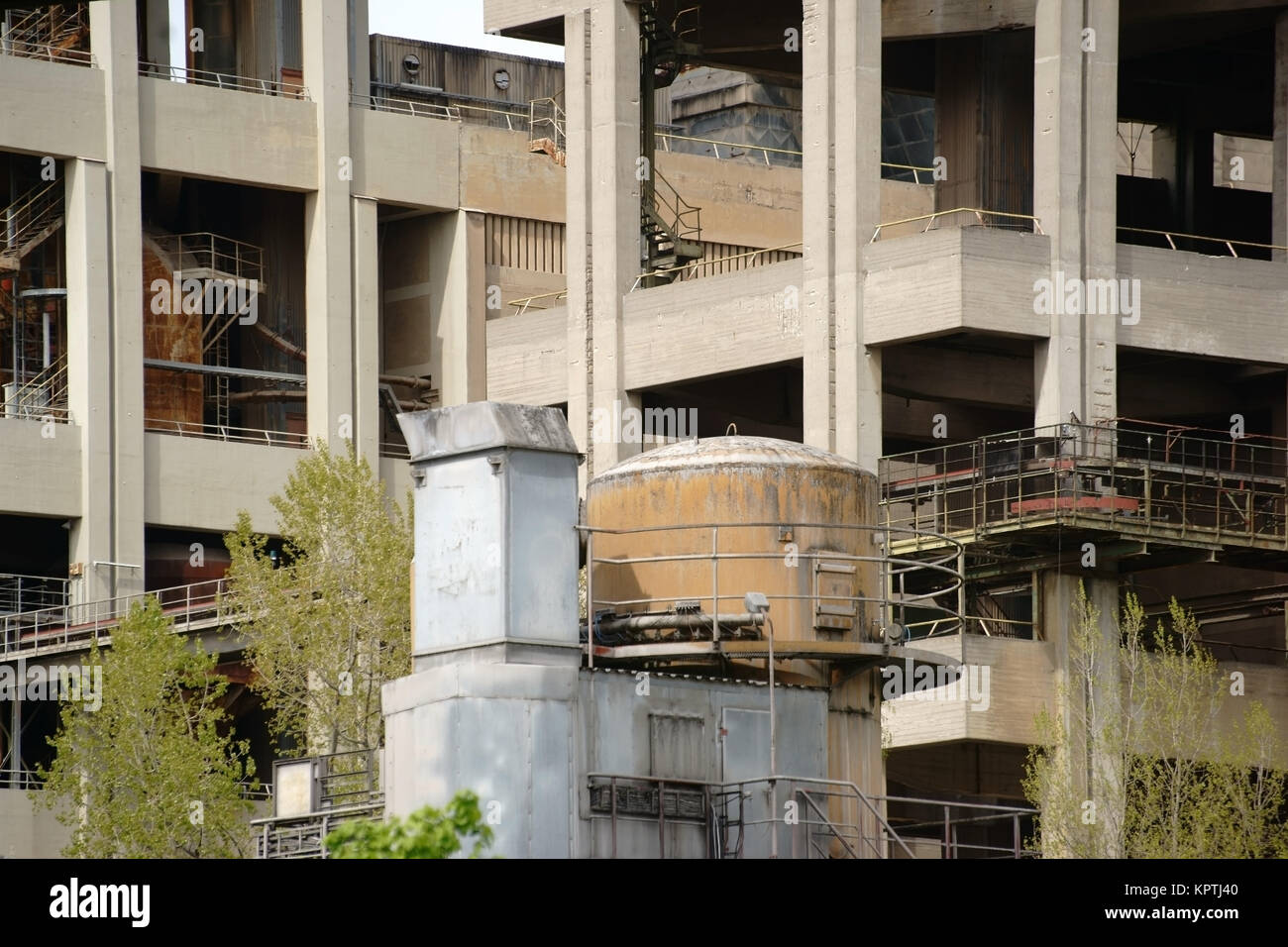 Eine alte verlassene Industrieruine mit verschiedenen Stockwerken und Rohren mit Silos. Stock Photo