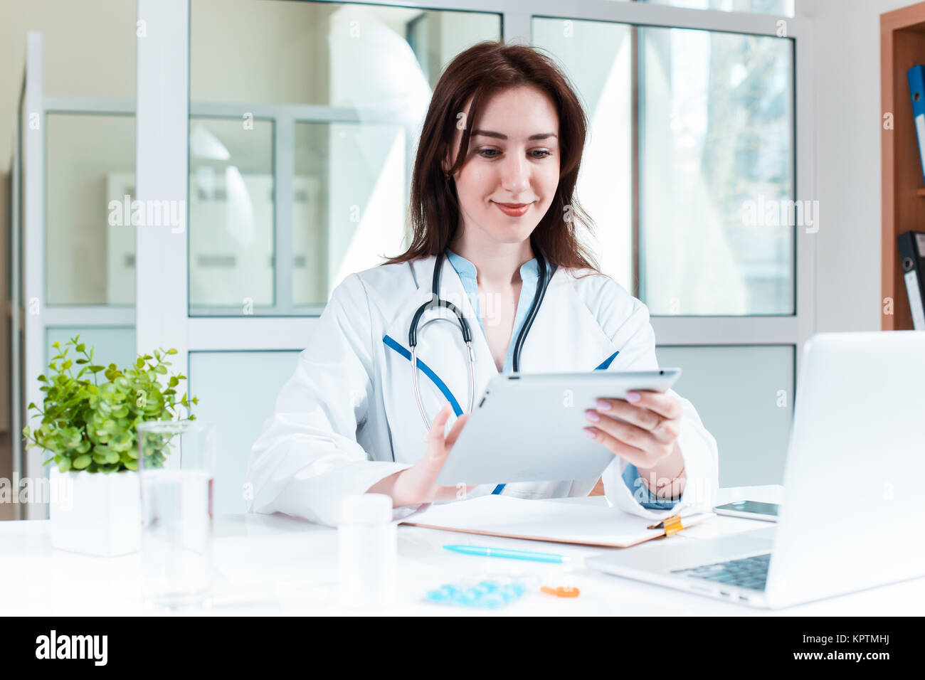 Woman doctor sitting at the table Stock Photo