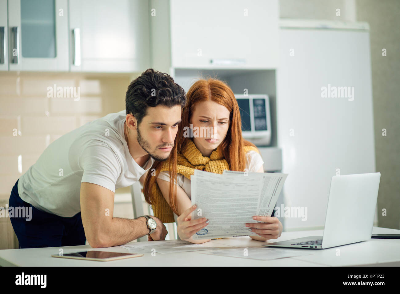 couple managing finances, reviewing bank accounts using laptop computer ...