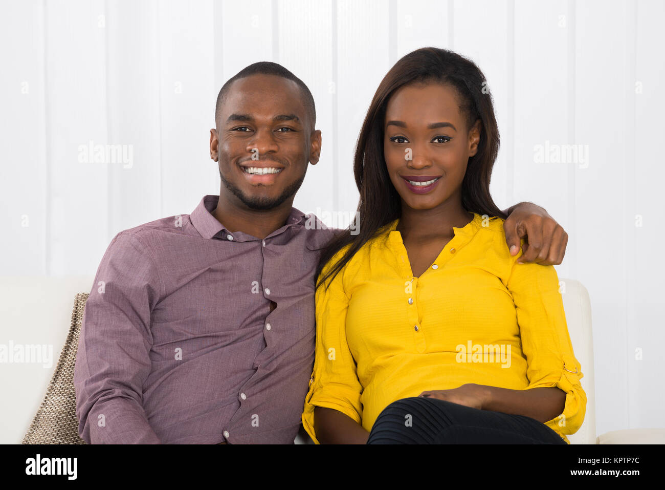Portrait Of Happy Young African Couple Sitting On Sofa Stock Photo - Alamy