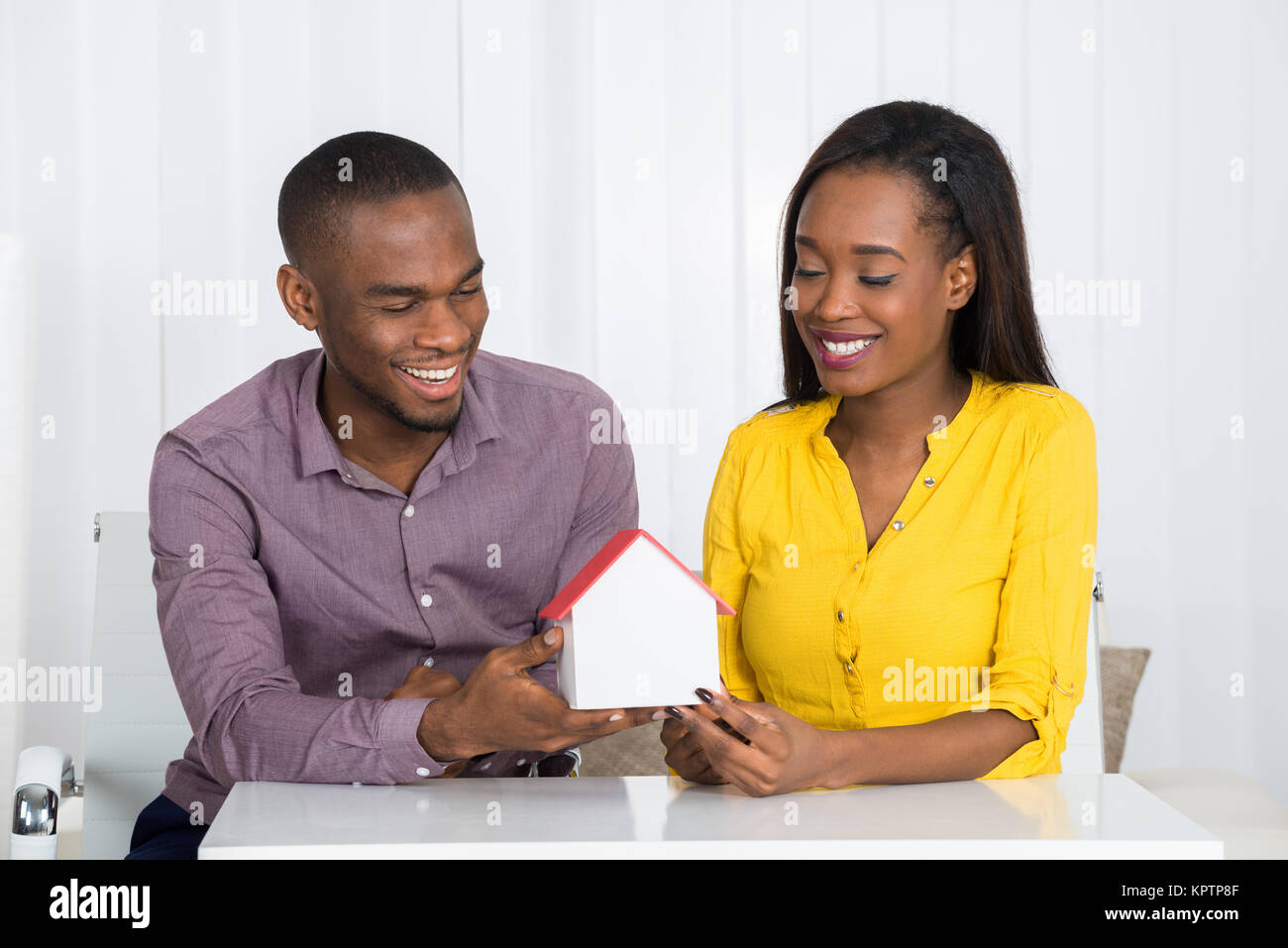 Young Happy African Couple Holding A House Model At Home Stock Photo ...