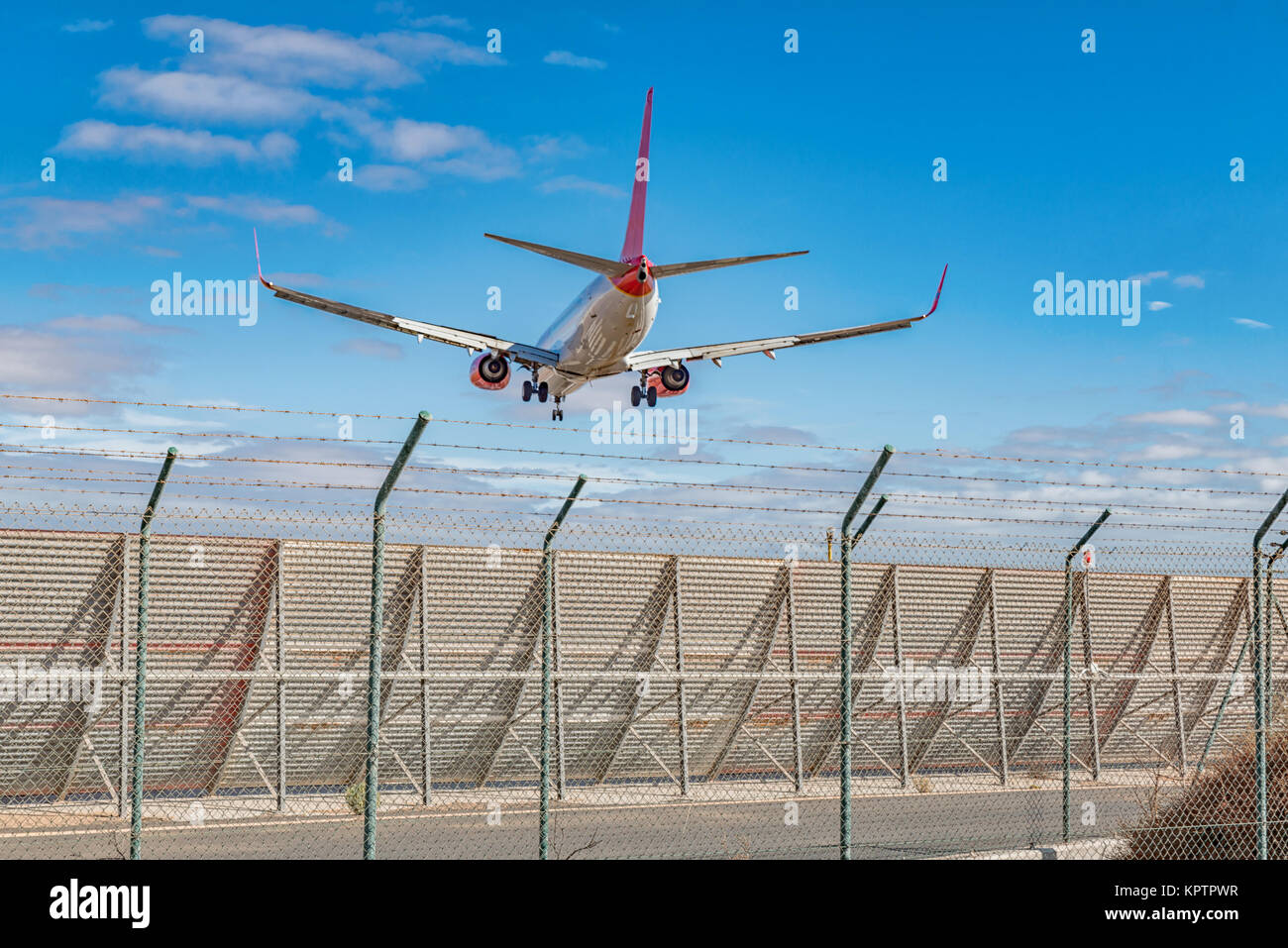 a plane flies over the border fence Stock Photo