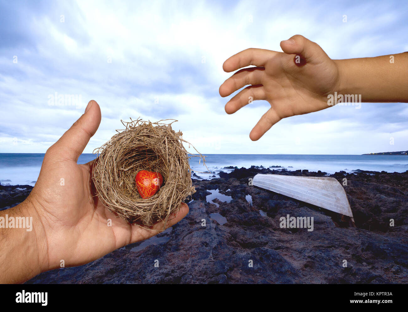 Human hands keep a natural nest with  a red heart inside and a child tries to reach this nest. Family bonds, protection, security, hope, solidarity. Stock Photo