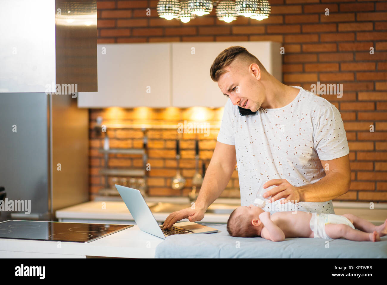Father Feeding His Baby While trying Working on laptop Stock Photo - Alamy