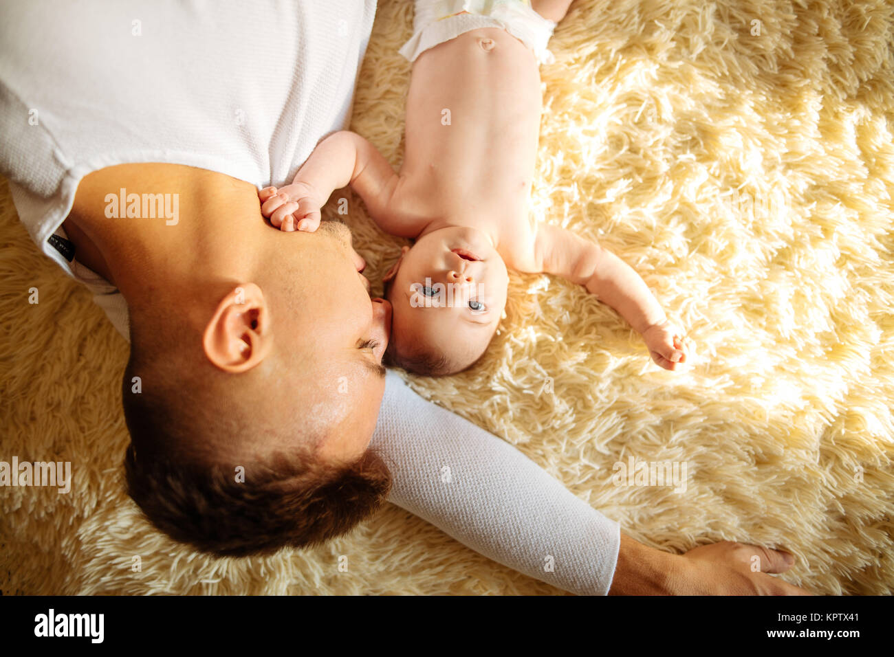 Father lying on bed and holds his baby Stock Photo - Alamy