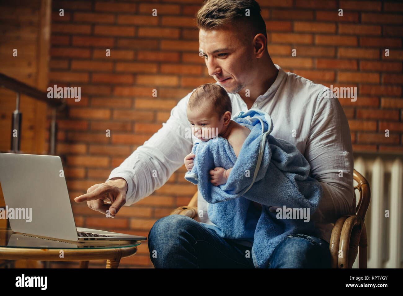 Father With Newborn Baby Working From Home Using Laptop Stock Photo Alamy