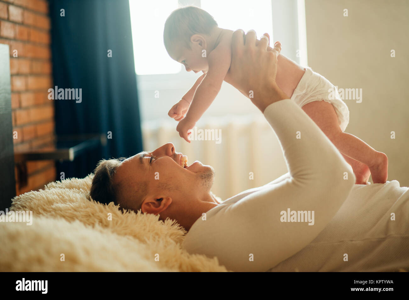 Father lying with cute baby daughter on bed Stock Photo - Alamy