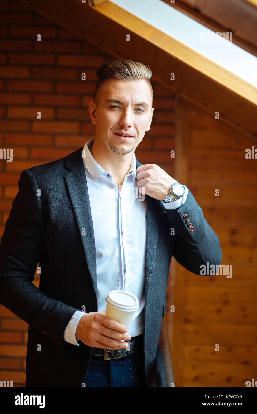 handsome businessman drinking coffee in home and looking away Stock Photo